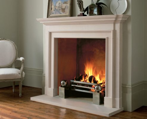 Chesneys’ Burlington fireplace in Portuguese limestone shown with the Soho fire basket and Spherical fire dogs